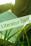 Ein Buch im Gras mit dem Schriftzug Literatur-Treff